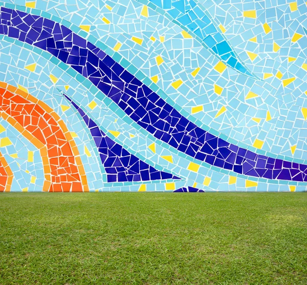 Parede de mosaico colorido azulejo e gramado verde — Fotografia de Stock