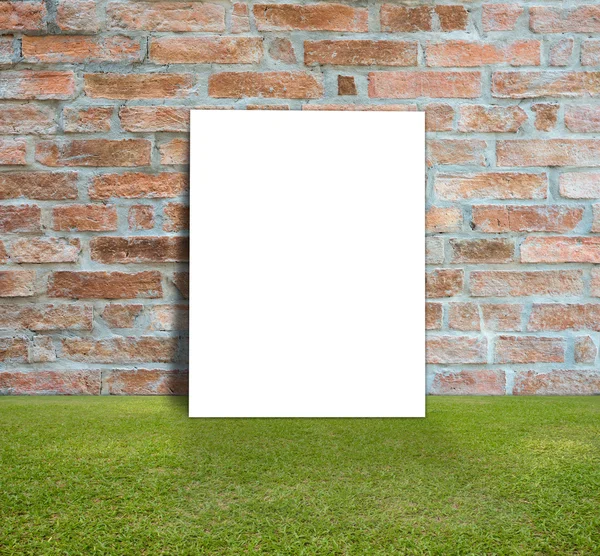Cartel en blanco con pared de ladrillo y césped verde para el mensaje de información — Foto de Stock