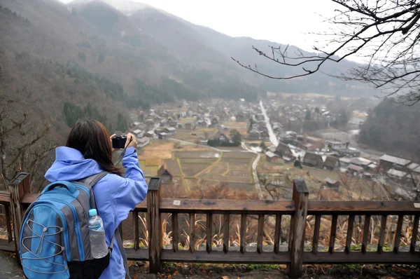 Randonneur touristique prendre une photo qui se composent du village de Skirakawago . — Photo