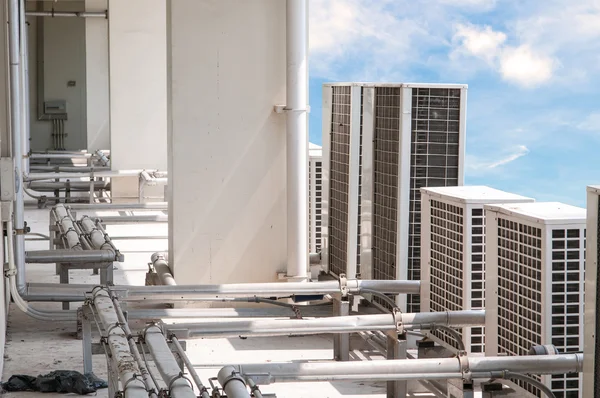 Birçok büyük hava kompresörü mavi gökyüzü arka plan ile çatı üzerinde.