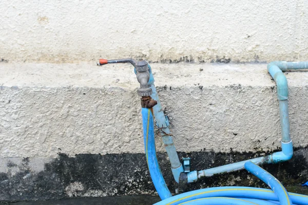 Grifo de agua viejo conectado a un tubo de goma — Foto de Stock