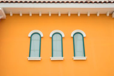Turuncu duvardaki yuvarlak kemer pencere