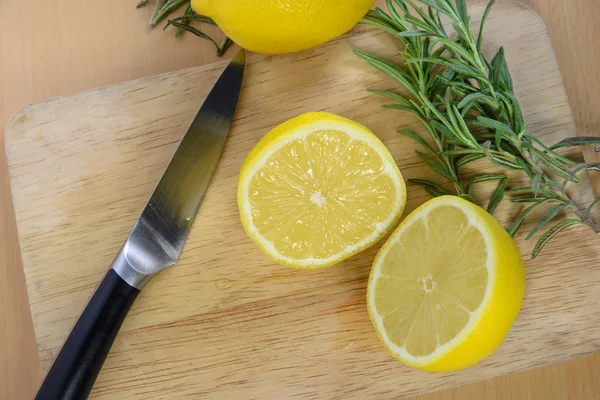 Citrons tranchés sur une planche à découper avec couteau — Photo