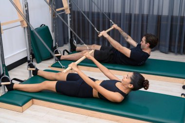 Erkekler ve kadınlar fiziksel sağlığı korumak için kaslarını güçlendirirler. Spor salonundaki pilates derslerini seven bir çift.