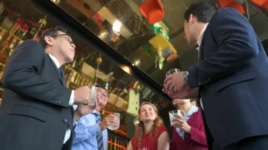 Çeşitli iş adamları modern bir ofis salonunda başarıyı ve takım çalışmasını neşeyle kutluyor. Başarı, ortaklık ve kurumsal mutluluk kavramı