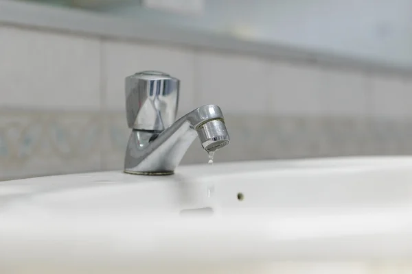 Капля воды из крана в ванной комнате — стоковое фото