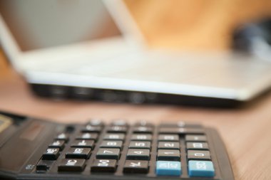 Hesap makinesi ve masanın üstünde laptop
