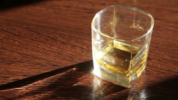 El whisky está sobre la mesa - la mano del hombre tomando un vaso HD — Vídeos de Stock