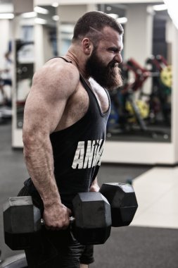 Spor salonunda ağırlık içinde çalışma dışarı fotoğraf vücut geliştirmeci