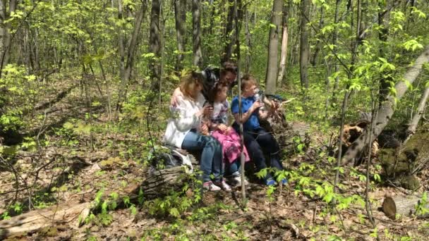 Wandelen familie ontspannen zitten in het bos — Stockvideo