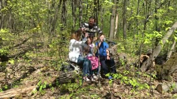 Hiking aile dinlenmek ormanda oturan — Stok video