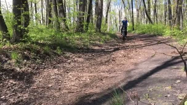 Хлопчик падає на велосипед у лісі. Повільний рух — стокове відео