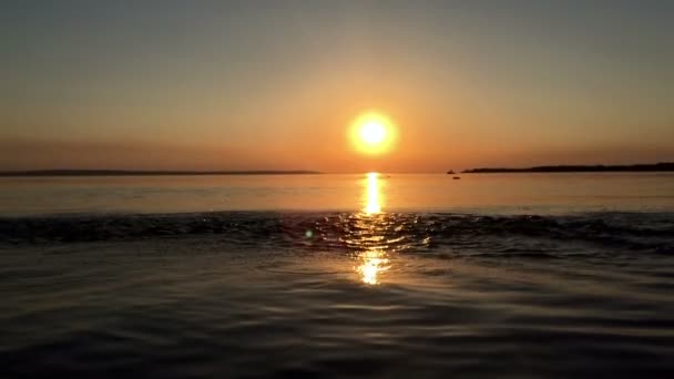 Дівчина гуляє по воді на заході сонця — стокове відео
