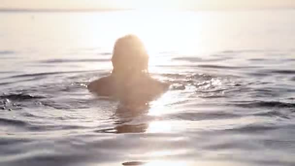 Una joven flota al atardecer — Vídeo de stock