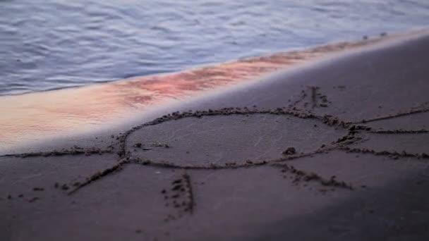 Sole disegnato jn spiaggia sabbia lavata via dalle onde — Video Stock