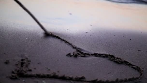 Coeur dessiné jn plage de sable emporté par les vagues — Video