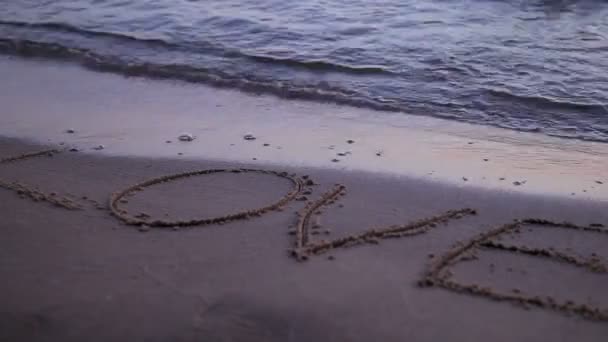 Liebe gezeichnet jn Strand Sand von Wellen weggespült — Stockvideo