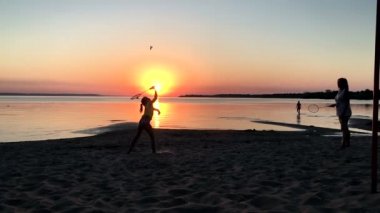 Anne ve kızı badminton oynamaya gün batımında