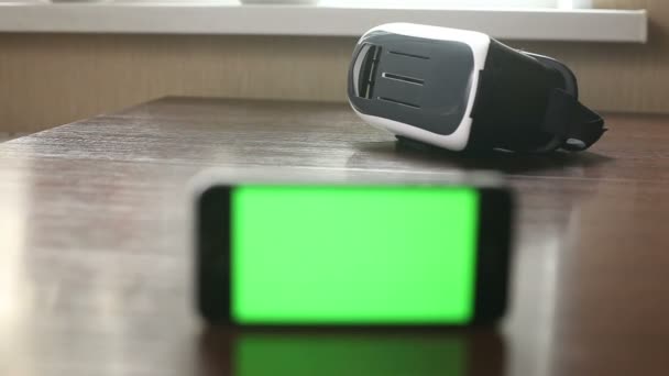 3D-headset en een mobiele telefoon op de tafel — Stockvideo