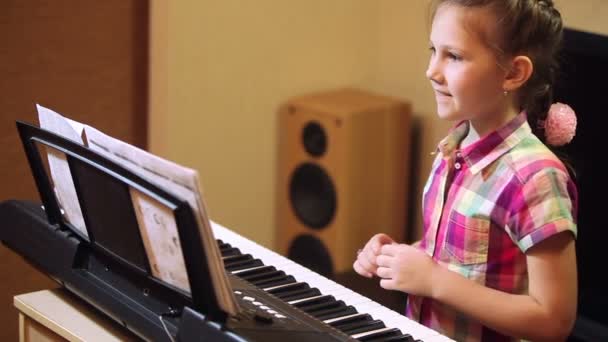 Genç kız bir synthesizer oynarken — Stok video