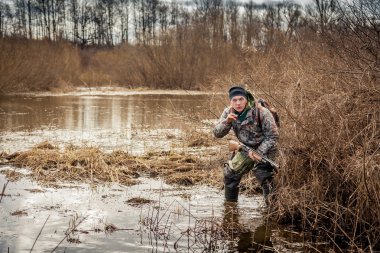 çalılar ve gösterileri jest dikkat gözlemliyor bataklık üzerinden sürünen avcı adam