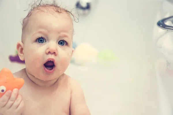 Baby with surprised face  looking at camera while having a bath — Stock Photo, Image