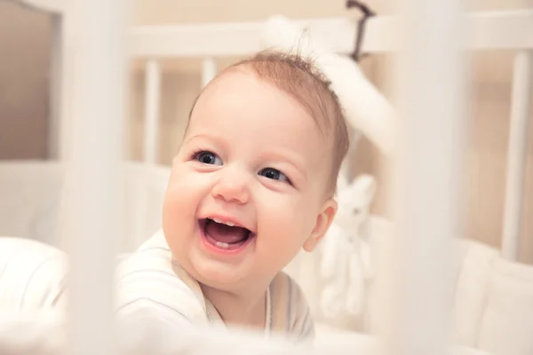 Funny laughing baby girl in cot — Stock Photo, Image