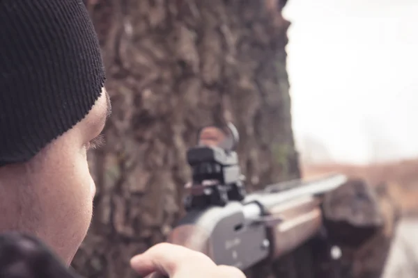 Человек с пистолетом прицеливается и готов сделать выстрел во время охоты — стоковое фото