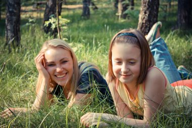 Anne ve kızı çimlerin üzerine park relax