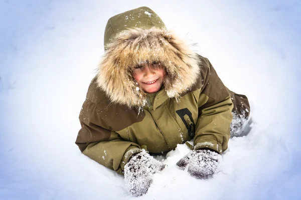 Pojken har kul i snön — Stockfoto