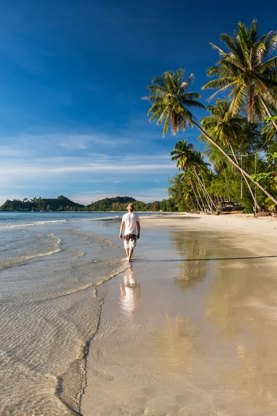 Мужчина расслабляется ходьба по тропическому пляжу — стоковое фото