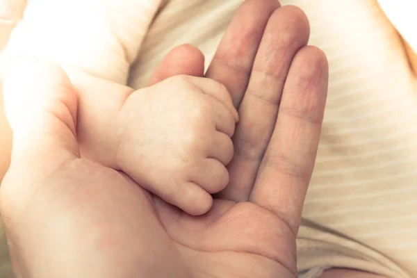 親の愛とケアを象徴する赤ちゃんの手を握って — ストック写真