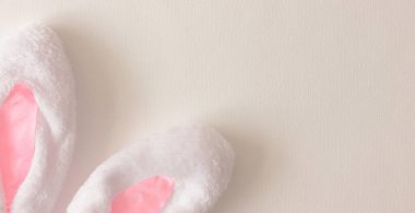 Kutsal Paskalya 'nın sembolü. Beyaz arka planda beyaz tavşan kulakları. Üst Manzara. Uzayı kopyala Paskalya geçmişi. Tasarım için arkaplan. Banner.