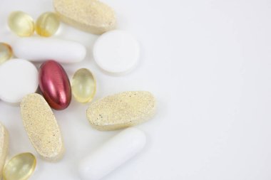 Beyaz arka planda farklı vitamin ve haplar var. Arka plan olarak kullanılabilir. Boşluğu kopyala.
