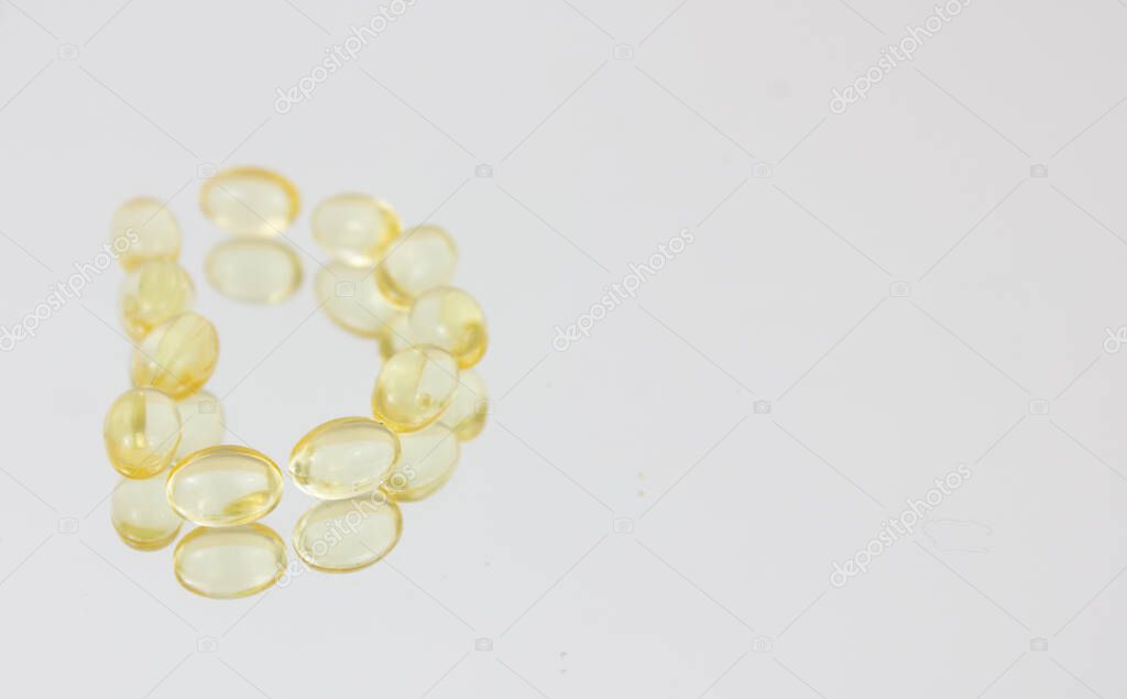 Yellow capsules form the letter D. Vitamin D. Copy space
