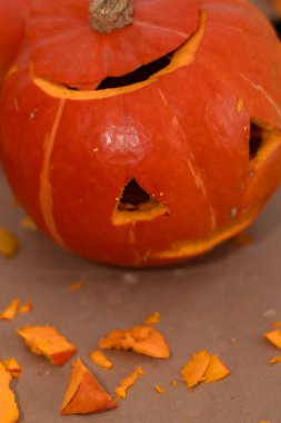 Creative Halloween pumpkin with carved designs and scattered scraps.
