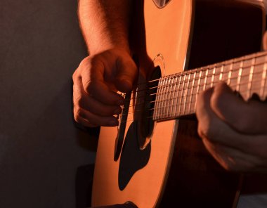 Bir adam karanlık bir odada gitar çalmayı öğrenir..