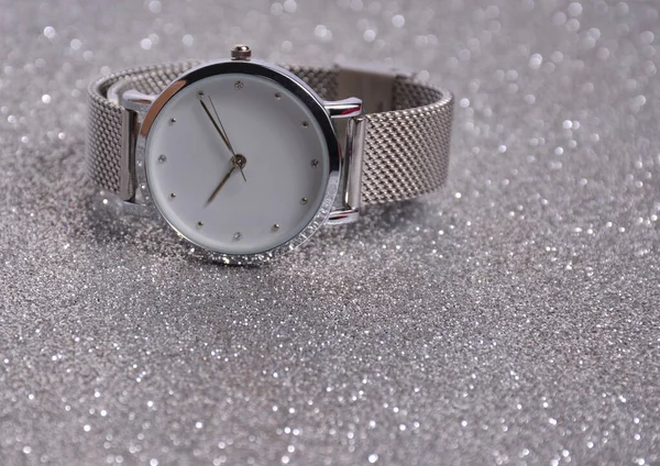 Women\'s watches lie on a silvery background.