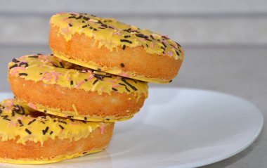 Beyaz bir tabakta üç sarı çörek..