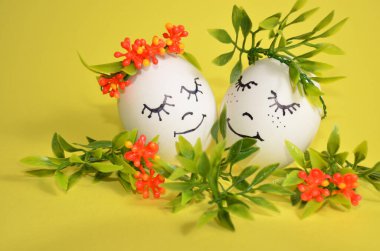 Sarı arka planda çiçekli iki Paskalya yumurtası..