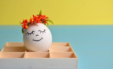 Sarı-mavi arka planda bir kutuda paskalya yumurtası. Paskalya.