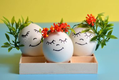 Sarı-mavi arka planda bir kutuda paskalya yumurtaları. Paskalya.