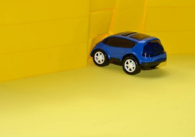 Sarı duvarın yanındaki mavi araba. Sarı arkaplan.