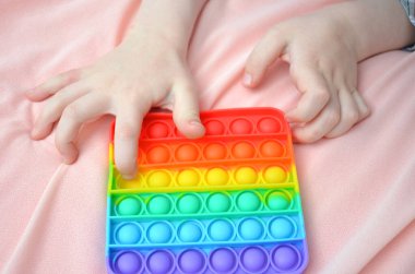 Pembe arka planda POP IT oyuncağı.