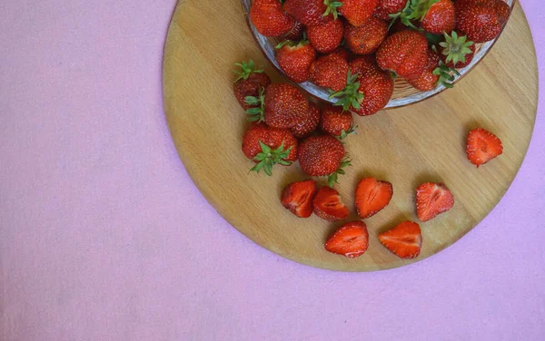 Erdbeeren auf einem Holzbrett. Erdbeeren mit grünen Blättern. — Stockfoto