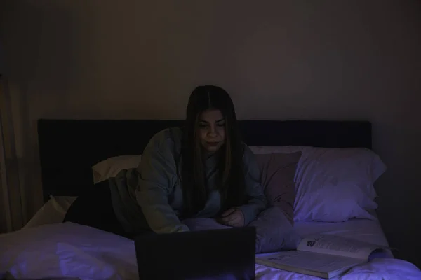 年轻妇女用电脑躺在床上 — 图库照片