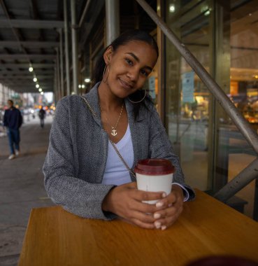 Koyu tenli kadın New York 'ta bir kafede kahve içiyor.