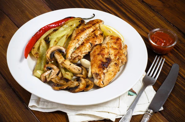 Otlar, mantar ve beyaz tabakta sebze ızgara tavuk göğsü