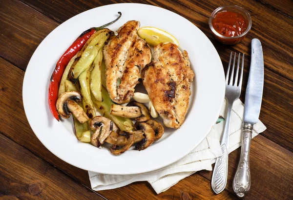 Gegrillte Hühnerbrüste mit Kräutern, Pilzen und Gemüse auf weißem Teller — Stockfoto