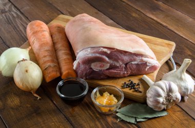 Soğan, havuç, sarımsak, karanfil, tatlım, ahşap üzerine soya sosu ile Çiğ domuz knuckle